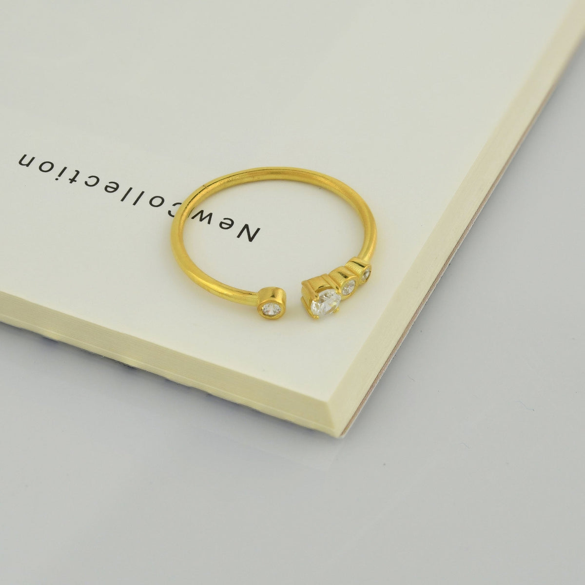 18K gold open four stone bezel diamond ring on display