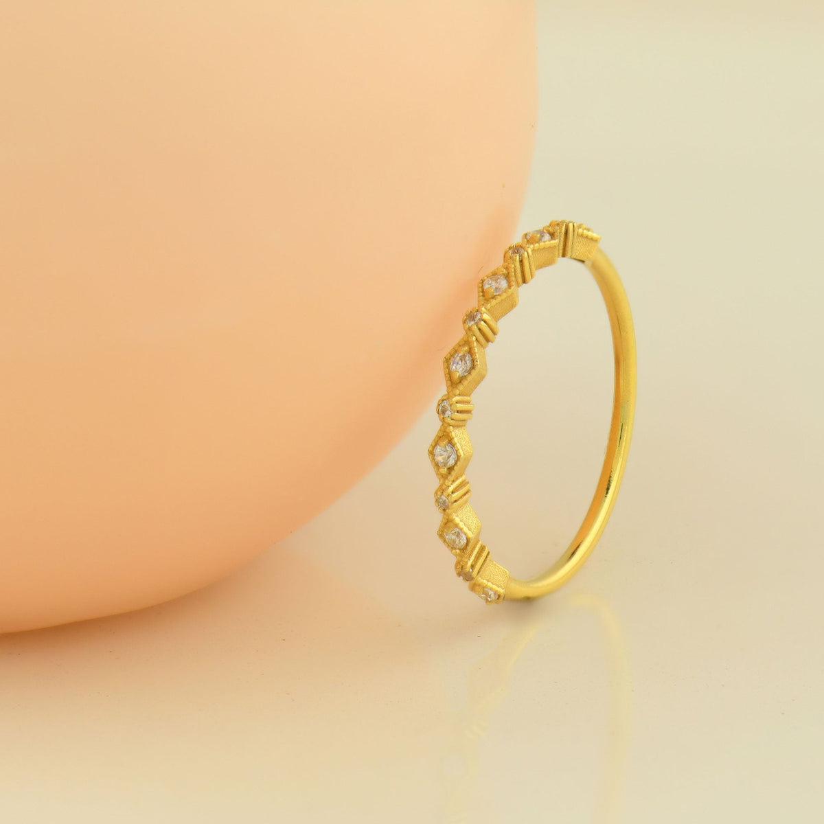 18K gold milgrain stackable cubic zirconia ring on display