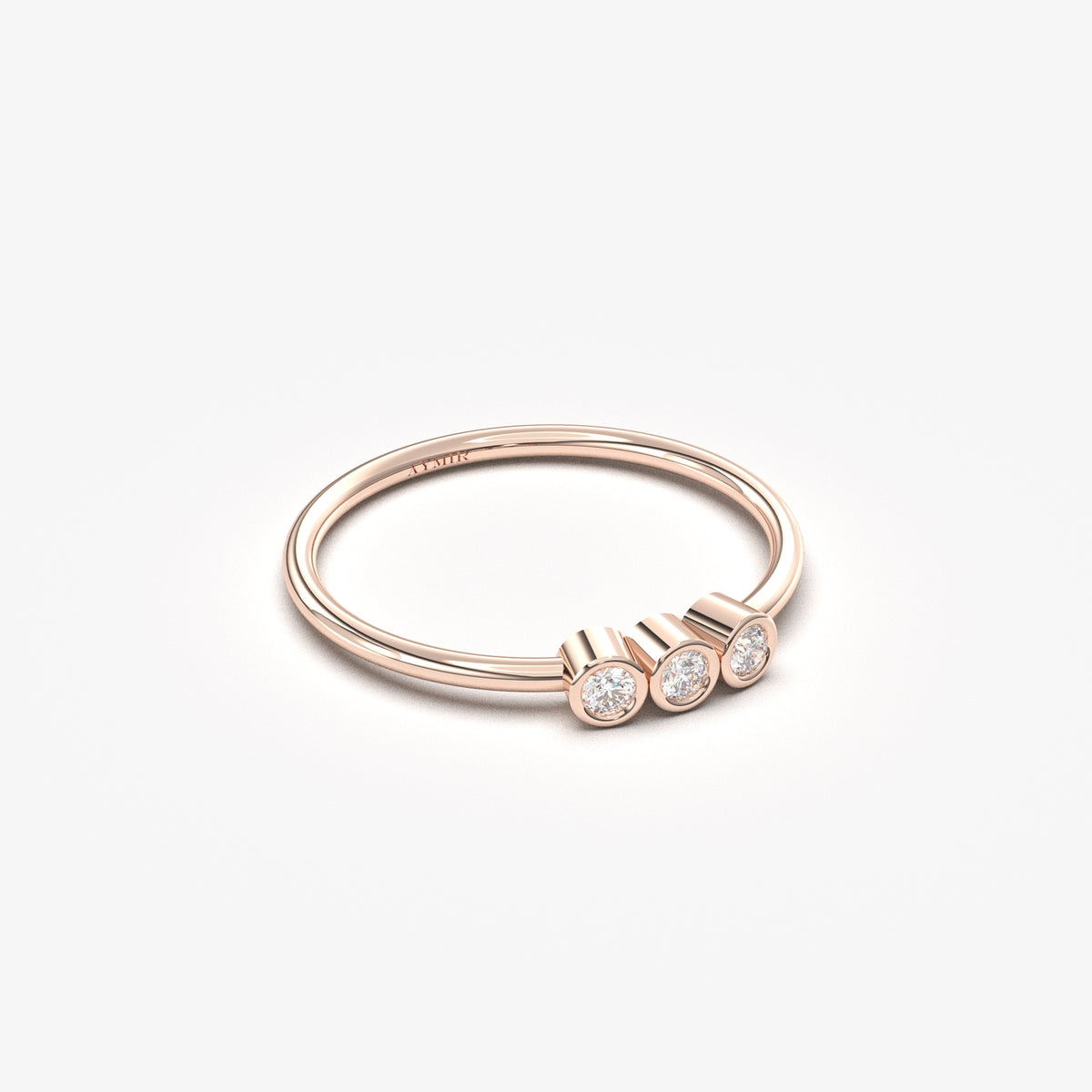 14K rose gold three stone bezel ring with cubic zirconia, angled view
