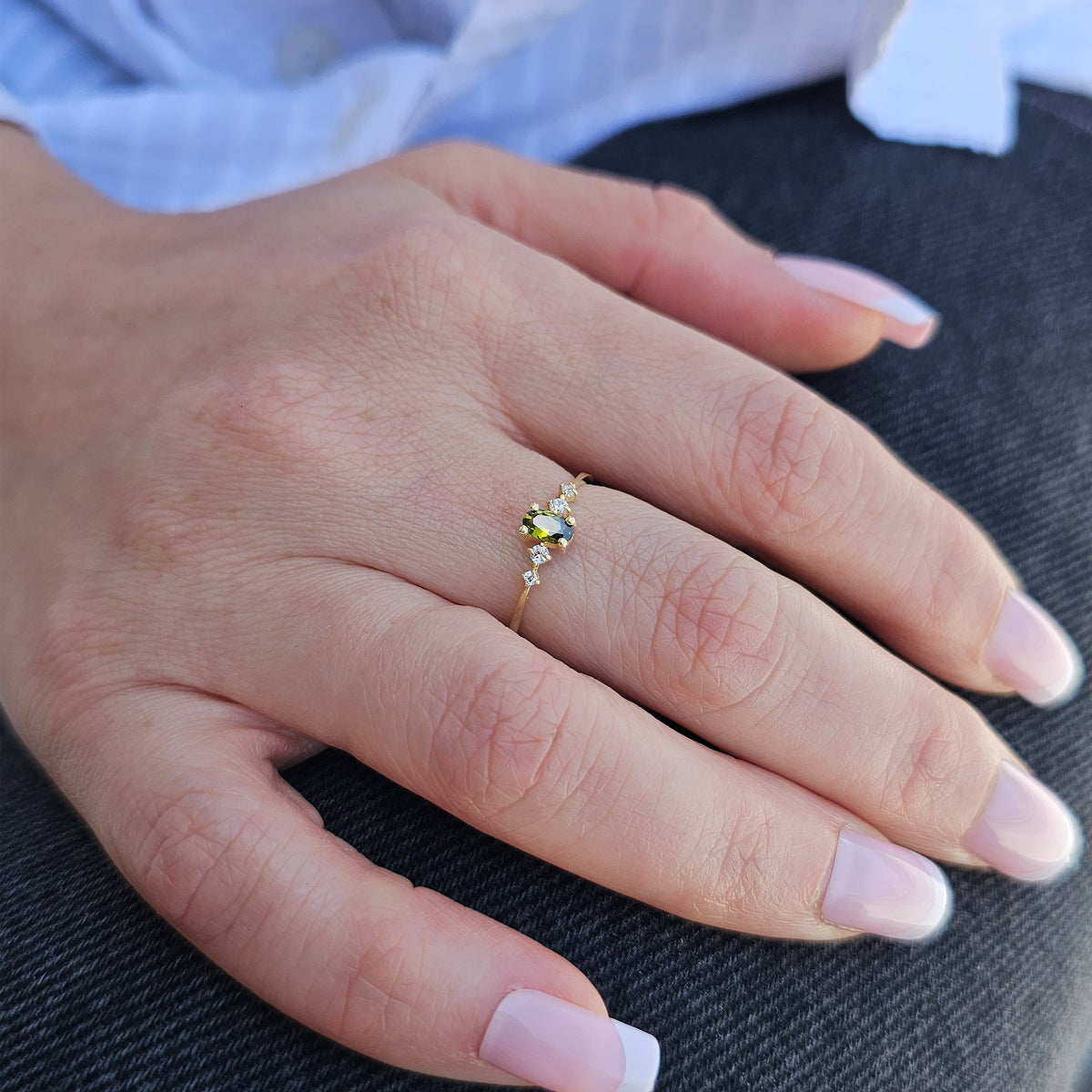 Gold green-stone oval ring worn on hand, close-up