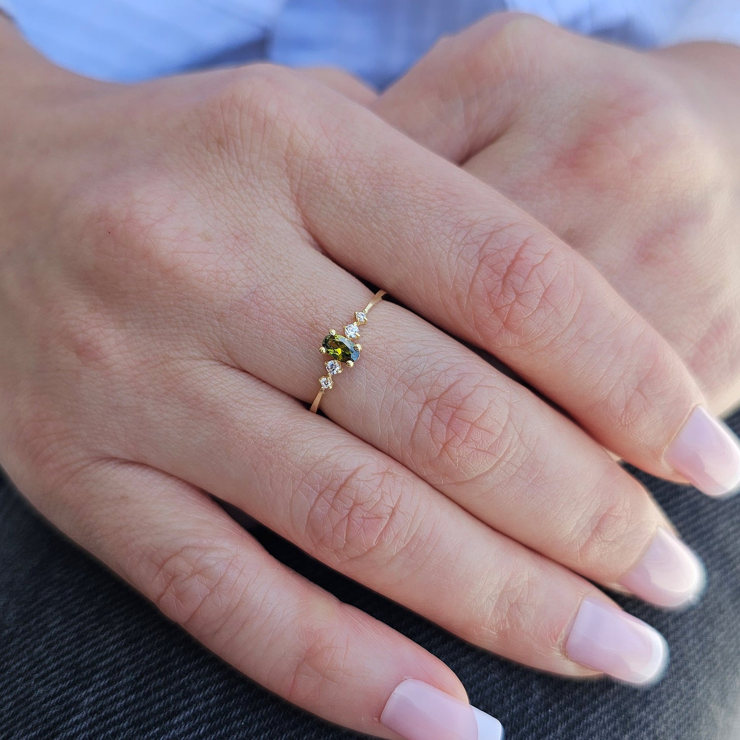 Gold green-stone oval ring worn on hand