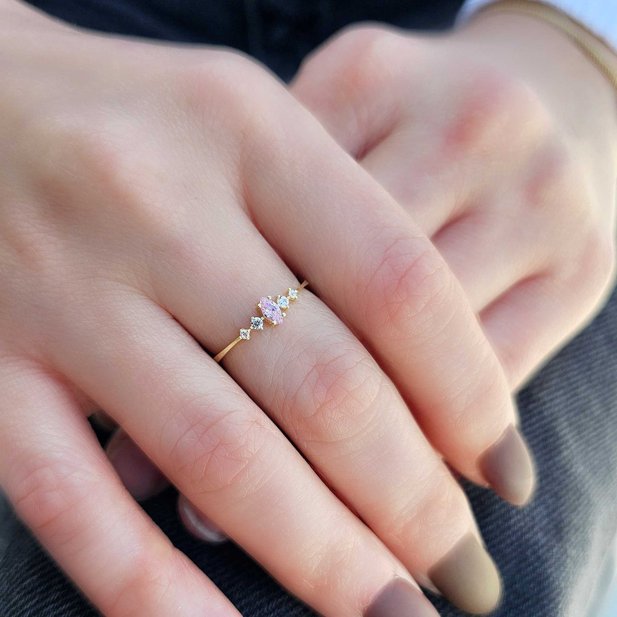 Gold pink-stone marquise ring worn on hand
