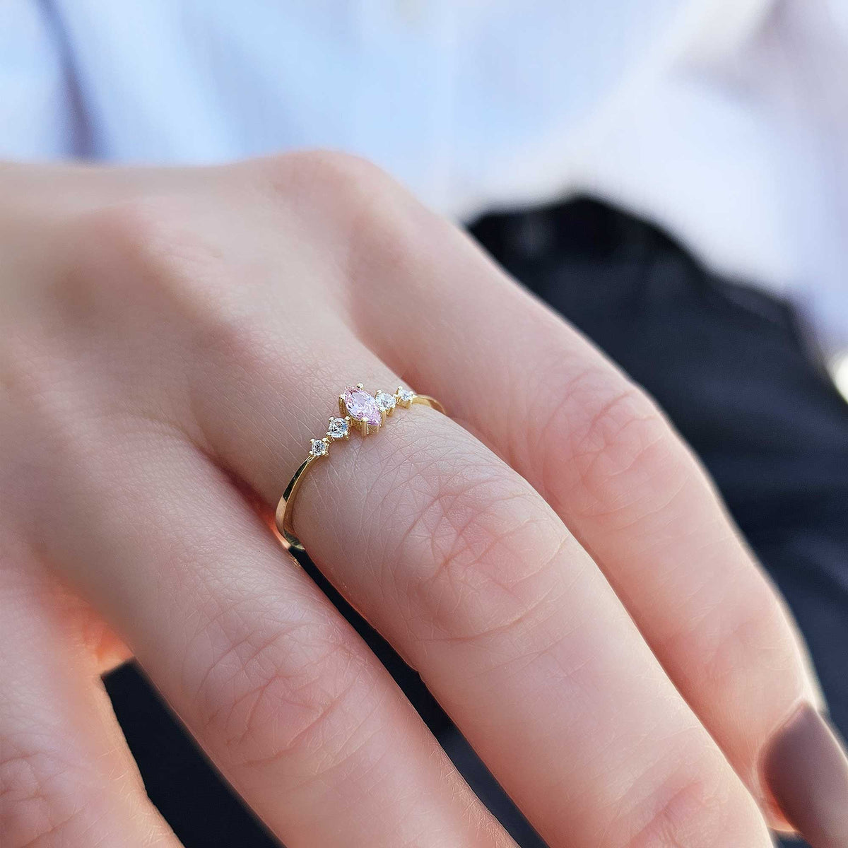 Gold pink-stone marquise ring worn on hand, side view