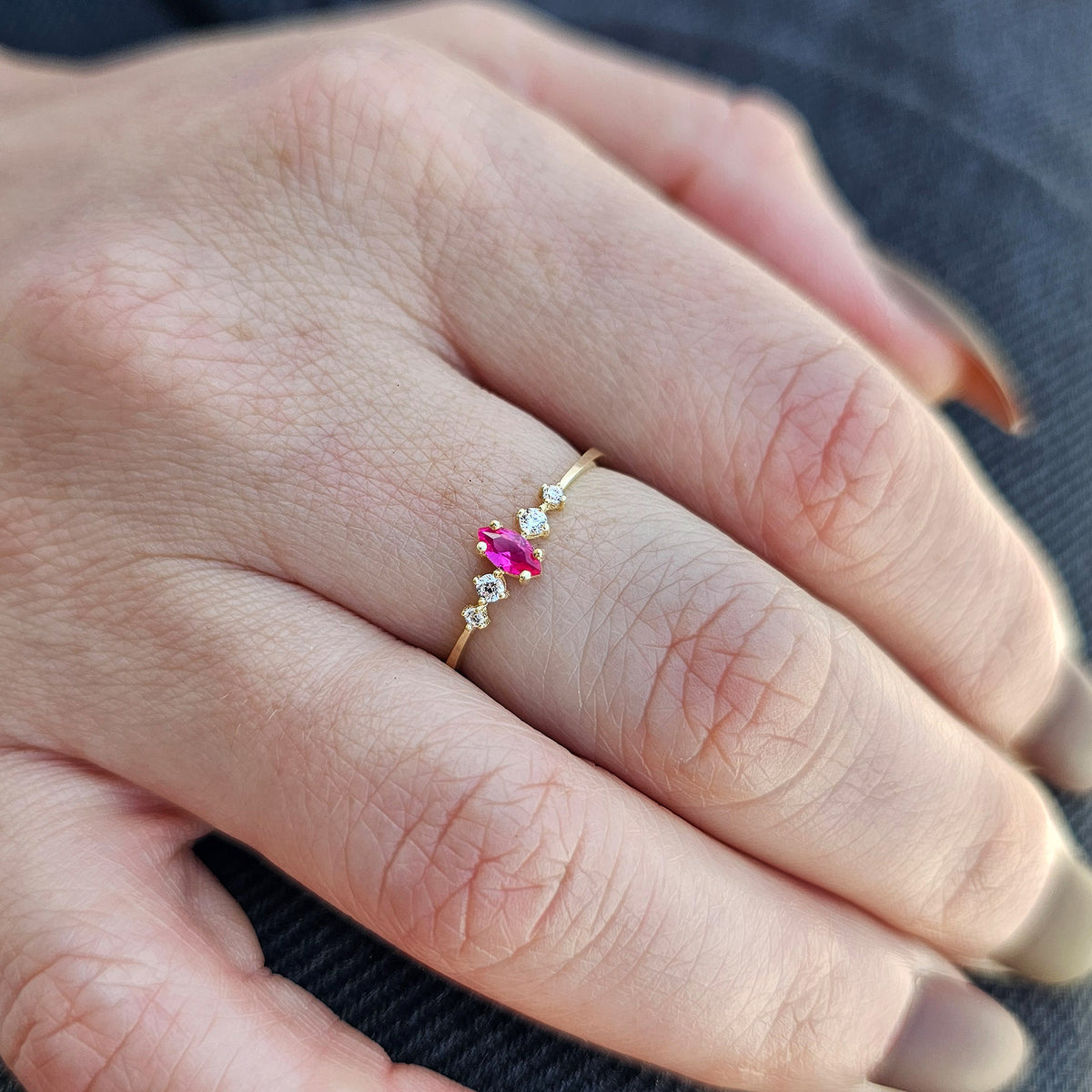 Gold red-stone marquise ring on raised hand