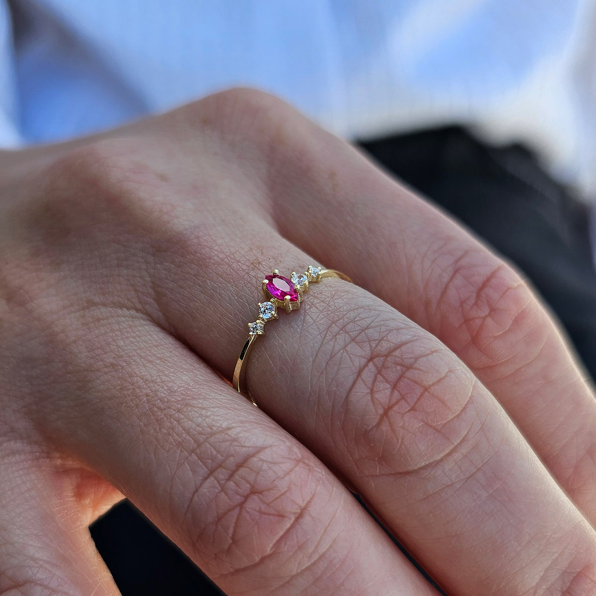 Gold red-stone marquise ring worn on hand, side view