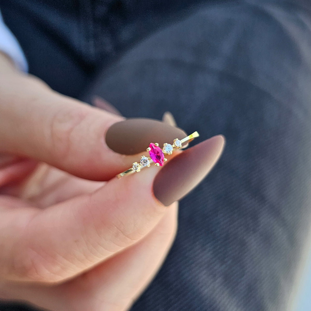 Gold red-stone marquise ring worn on hand, close-up