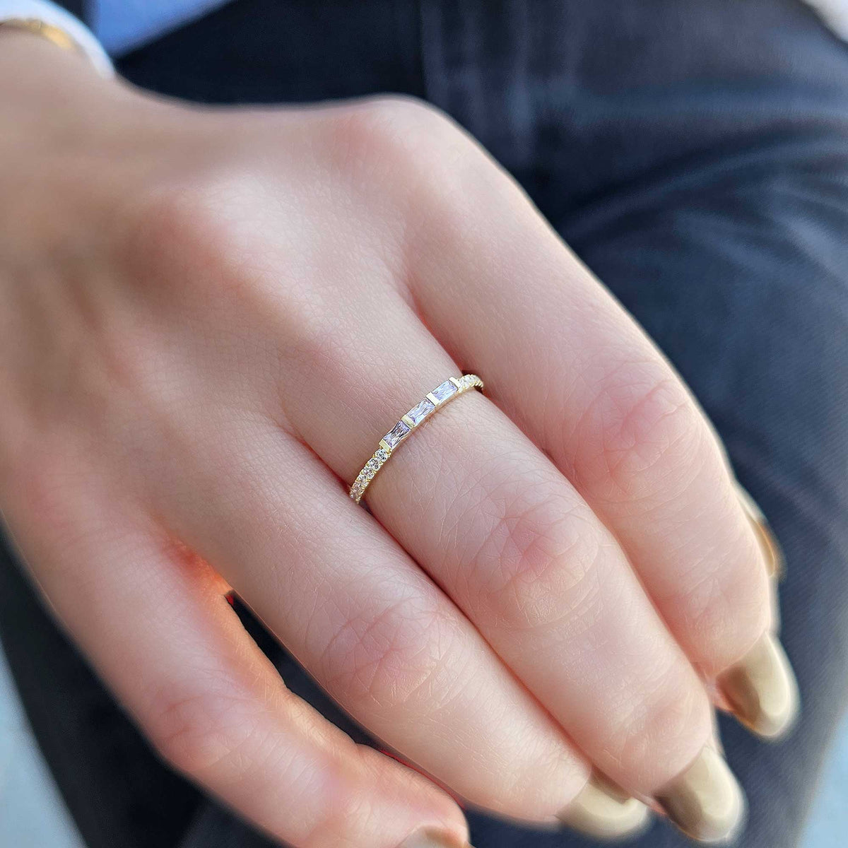 Gold lavender-stone baguette ring worn on hand, close-up