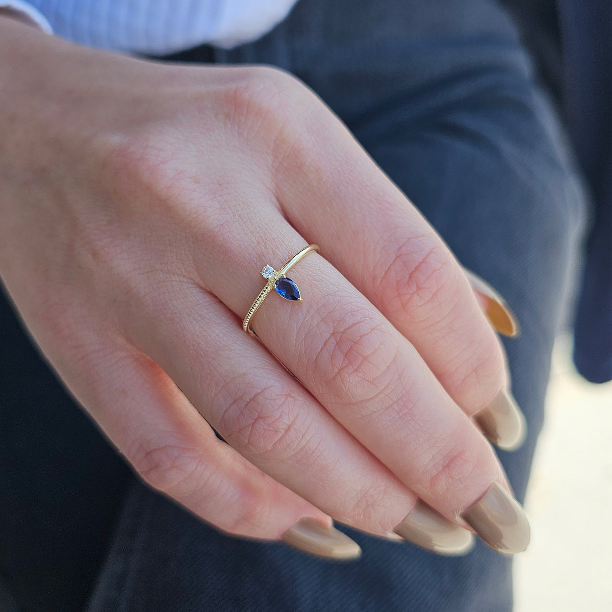 Gold blue-stone pear ring worn on hand