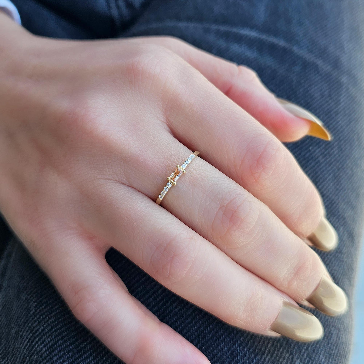 Gold champagne-stone baguette ring worn on hand