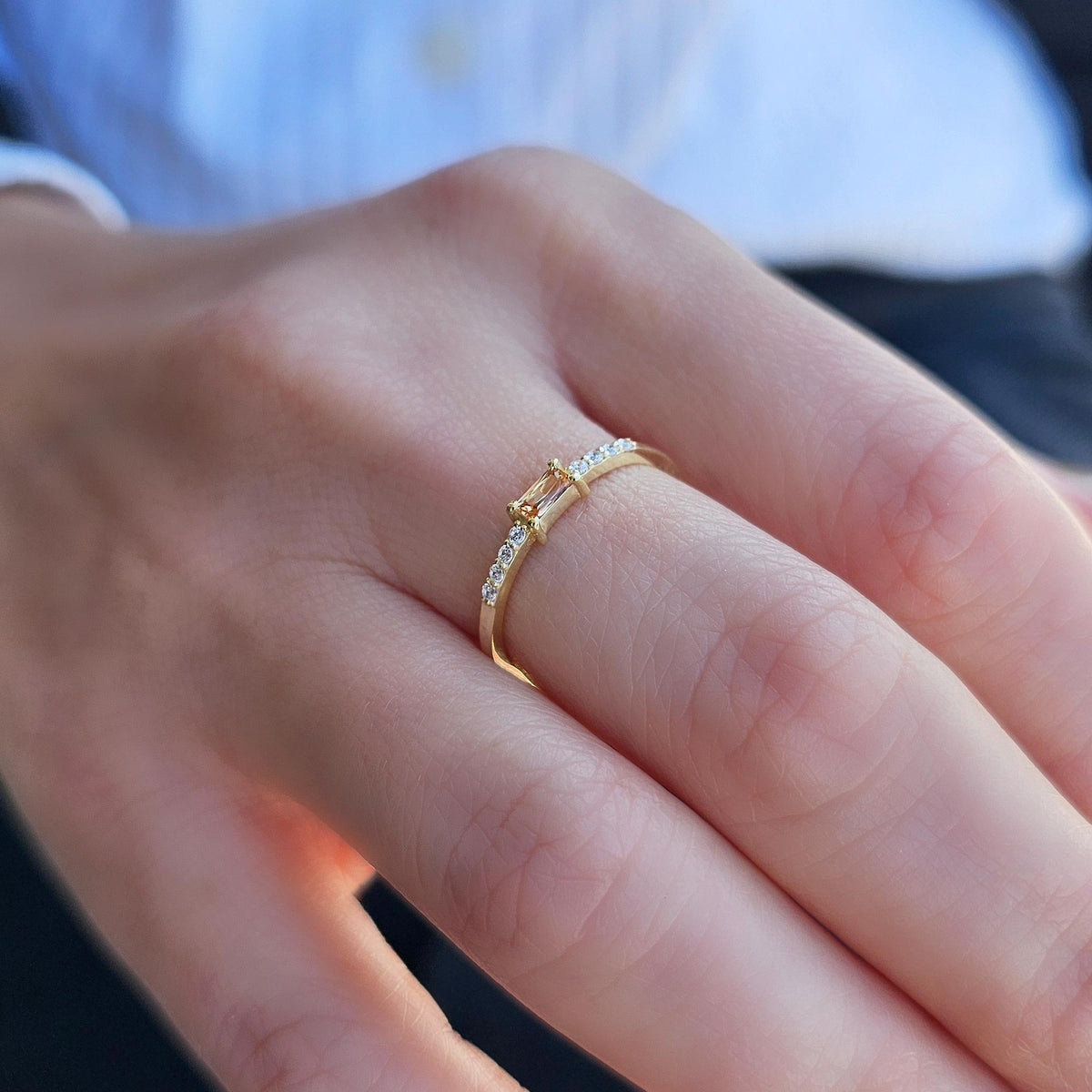 Gold champagne-stone baguette ring worn on hand, side view
