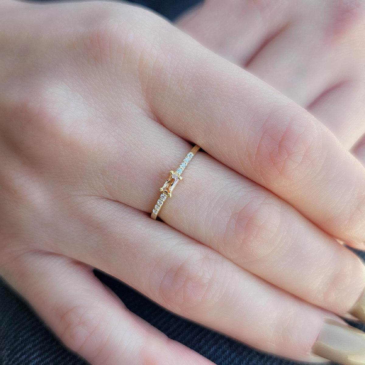 Gold champagne-stone baguette ring worn on hand, close-up