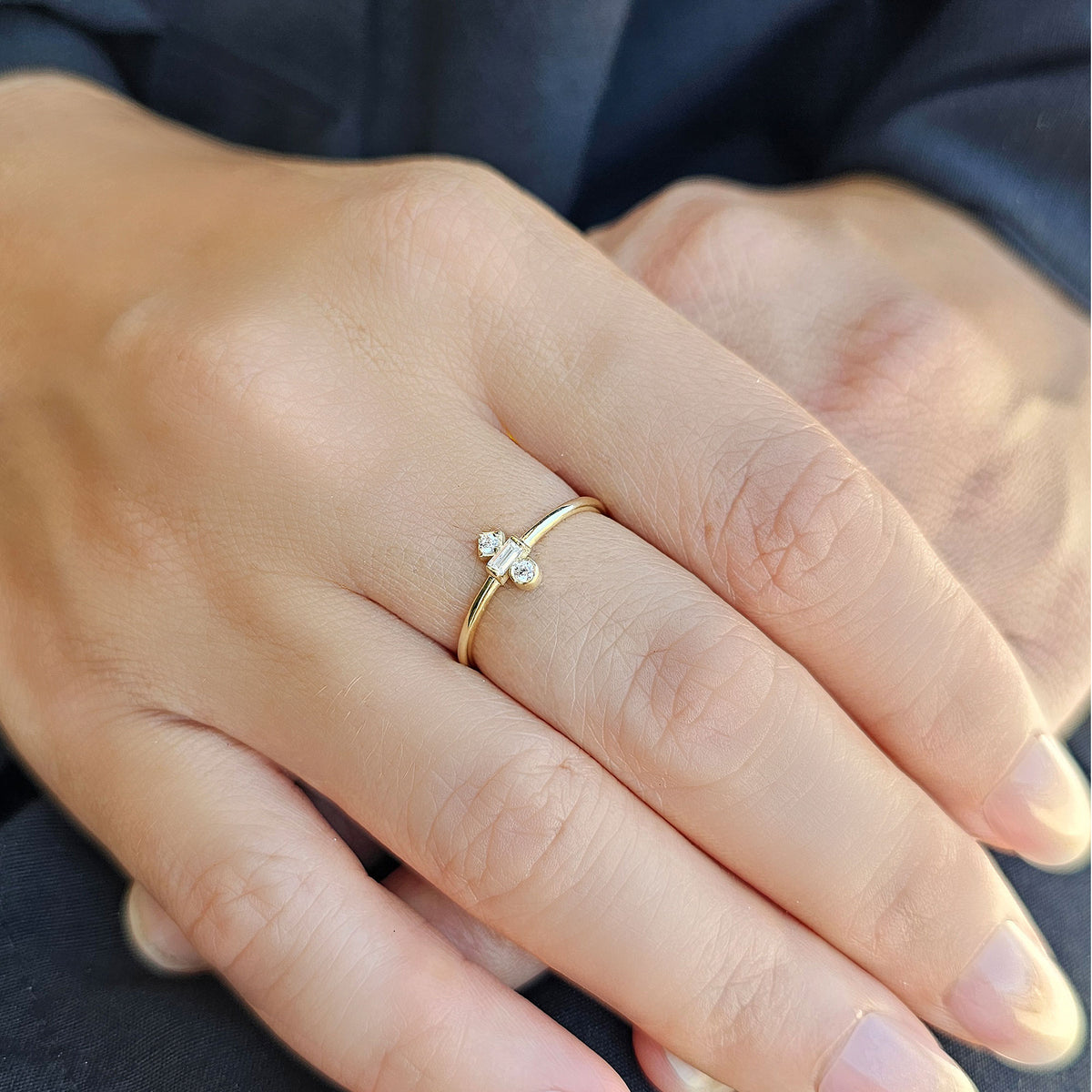 Gold three-stone baguette ring worn on hand