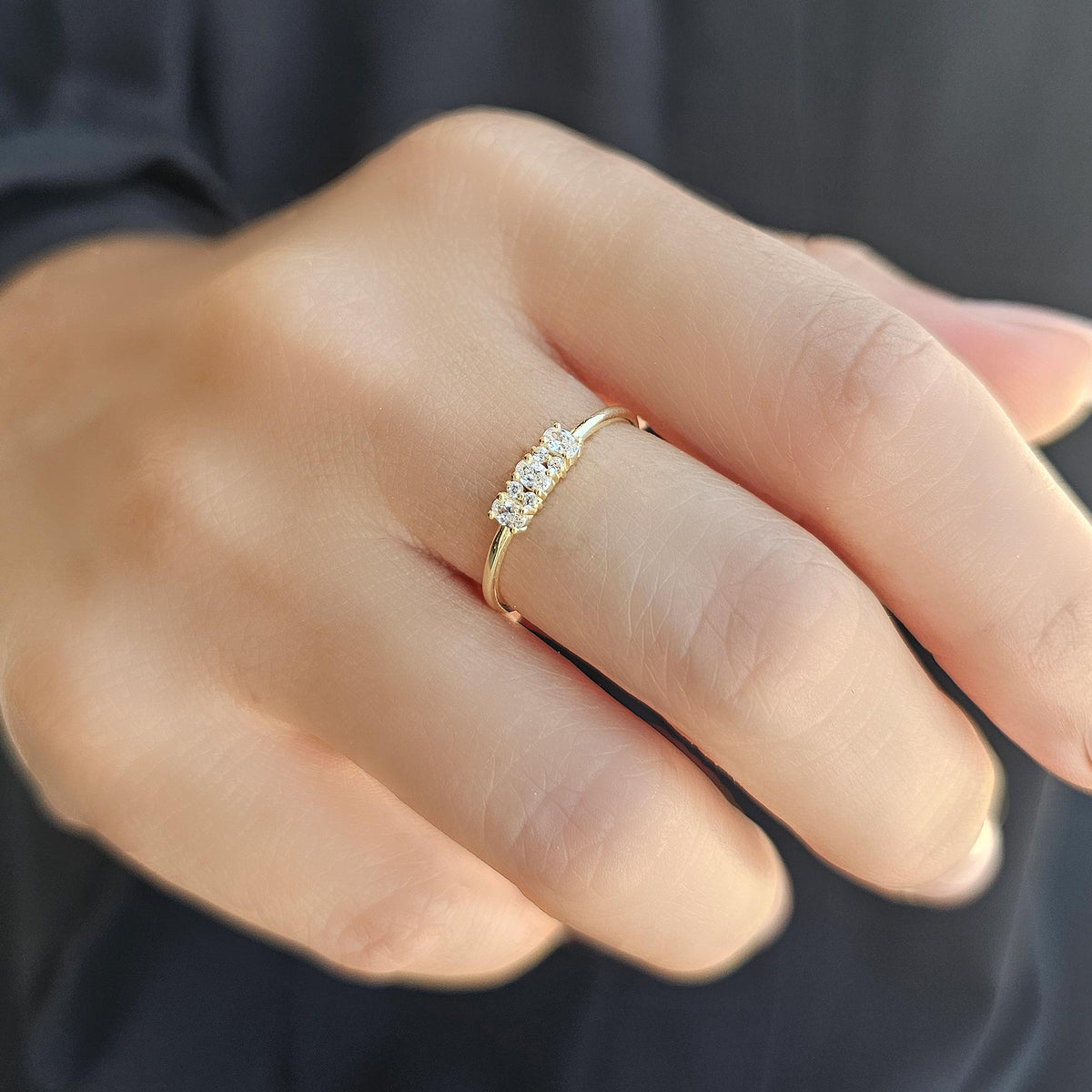 Gold three-oval ring worn on hand, side view