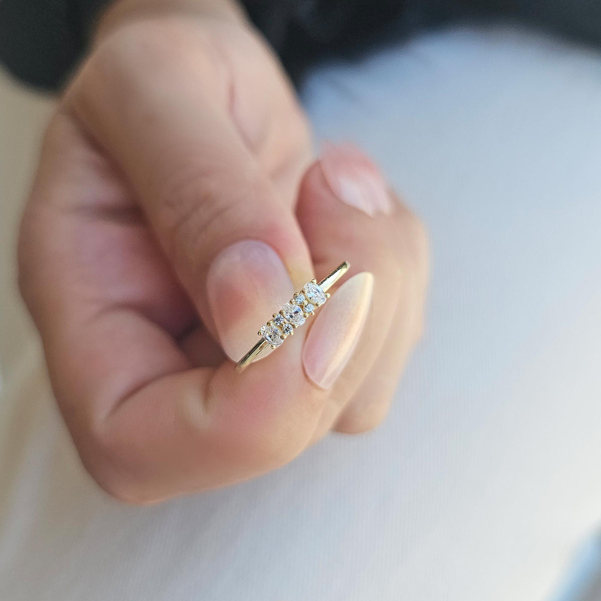 Gold three-oval ring on raised hand