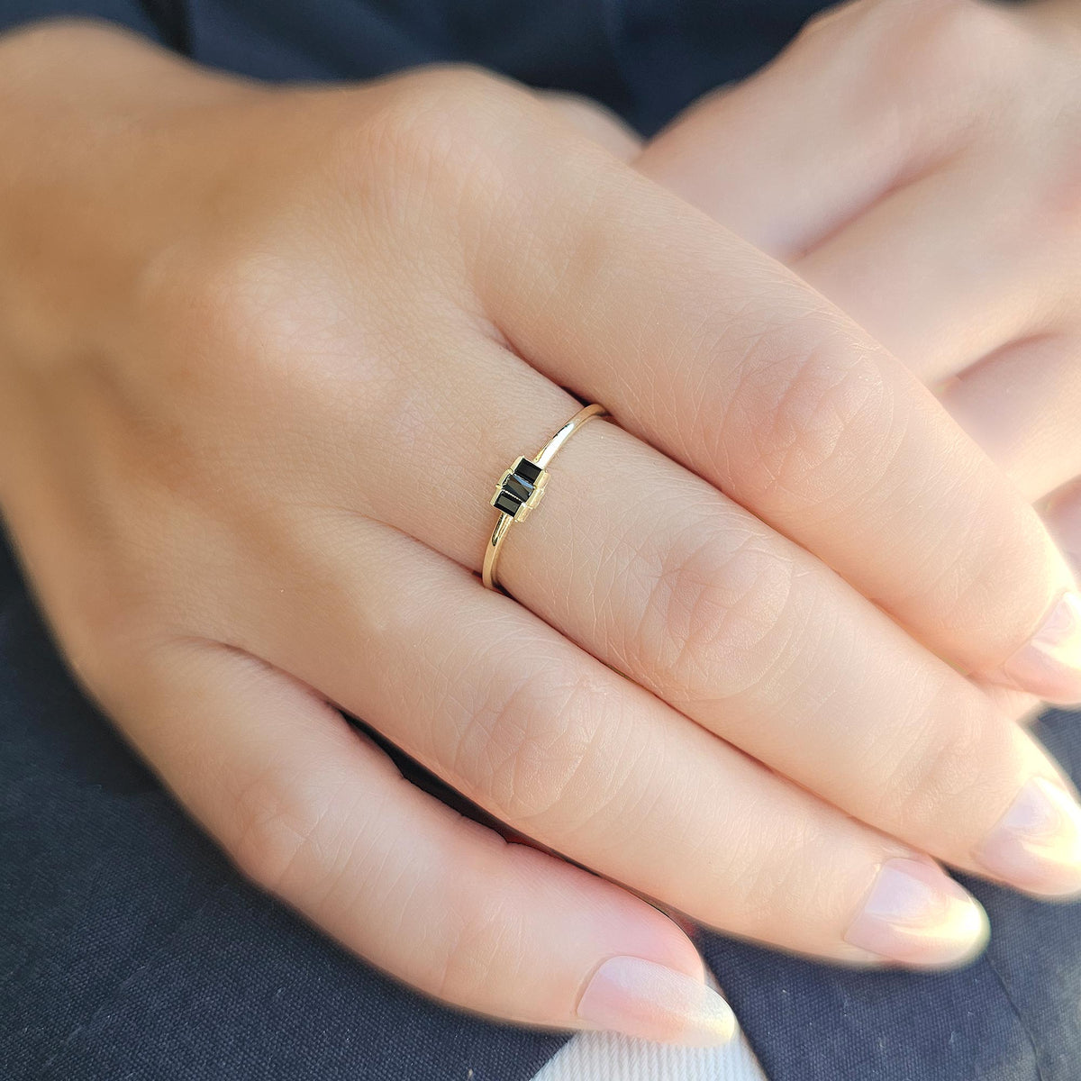 Gold black onyx three-baguette ring worn on hand
