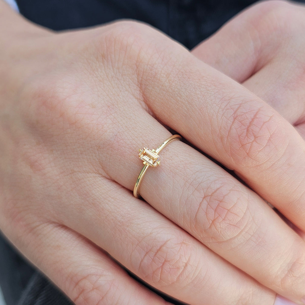 Gold champagne-stone baguette solitaire ring worn on hand