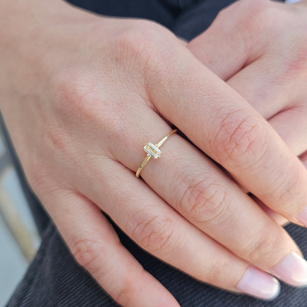 Gold lemon-yellow-stone baguette solitaire ring worn on hand