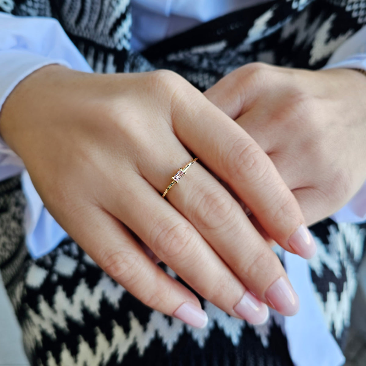 Gold pink-stone baguette solitaire ring worn on hand