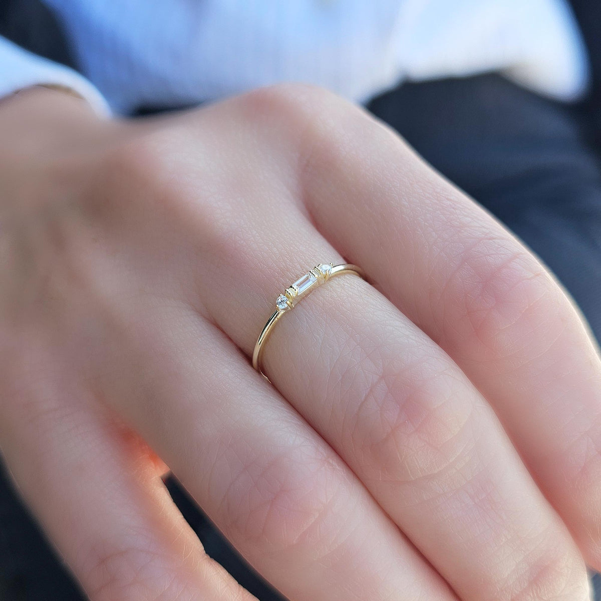 Gold bezel baguette ring worn on hand, side view