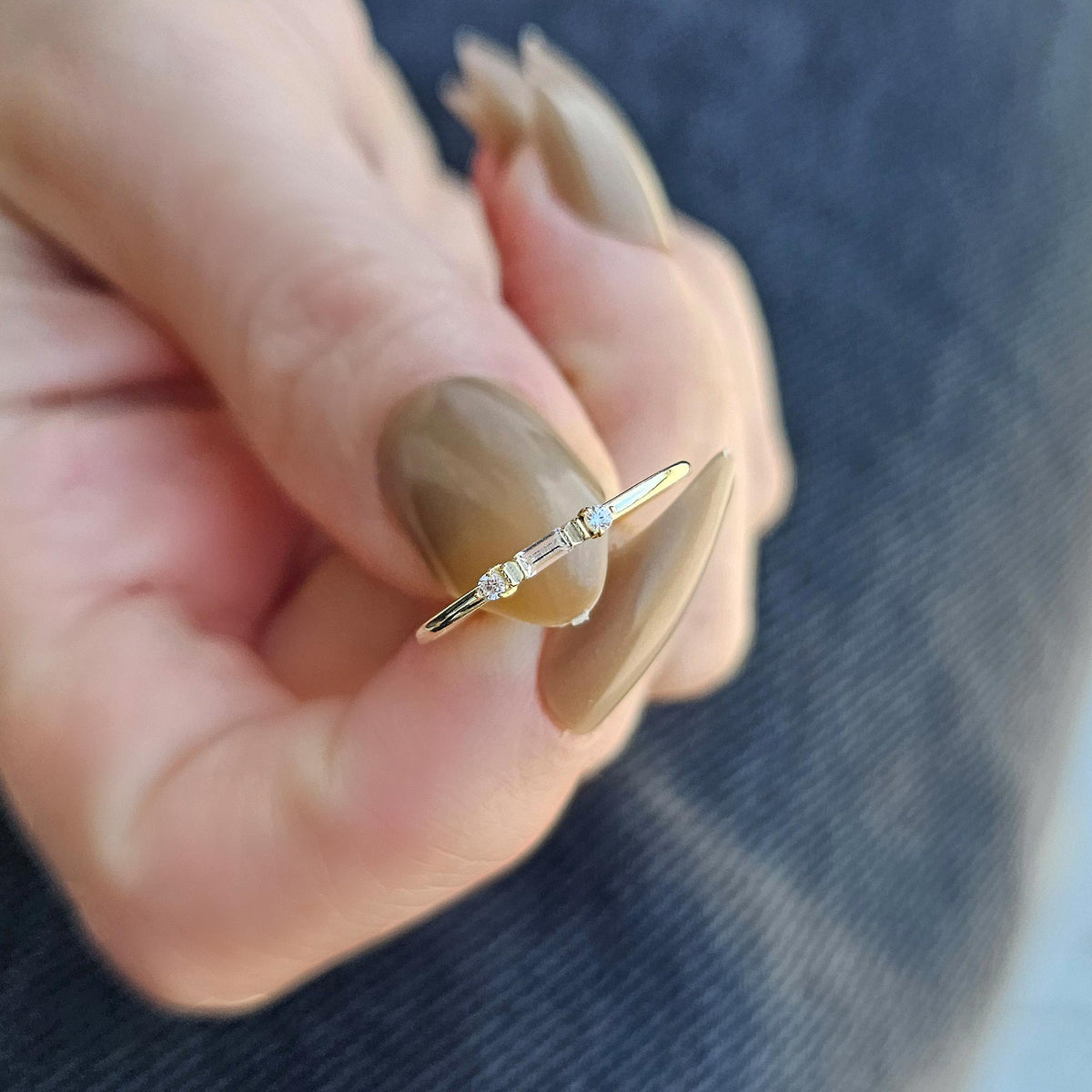 Gold bezel baguette ring worn on hand, close-up