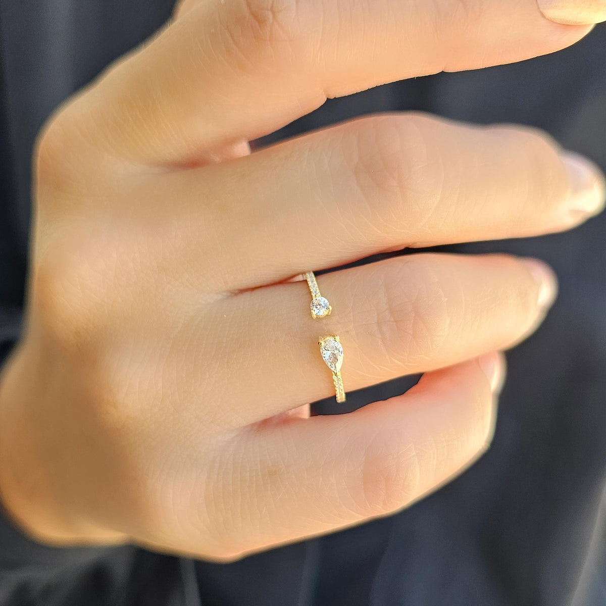 Gold pear open ring worn on hand, close-up
