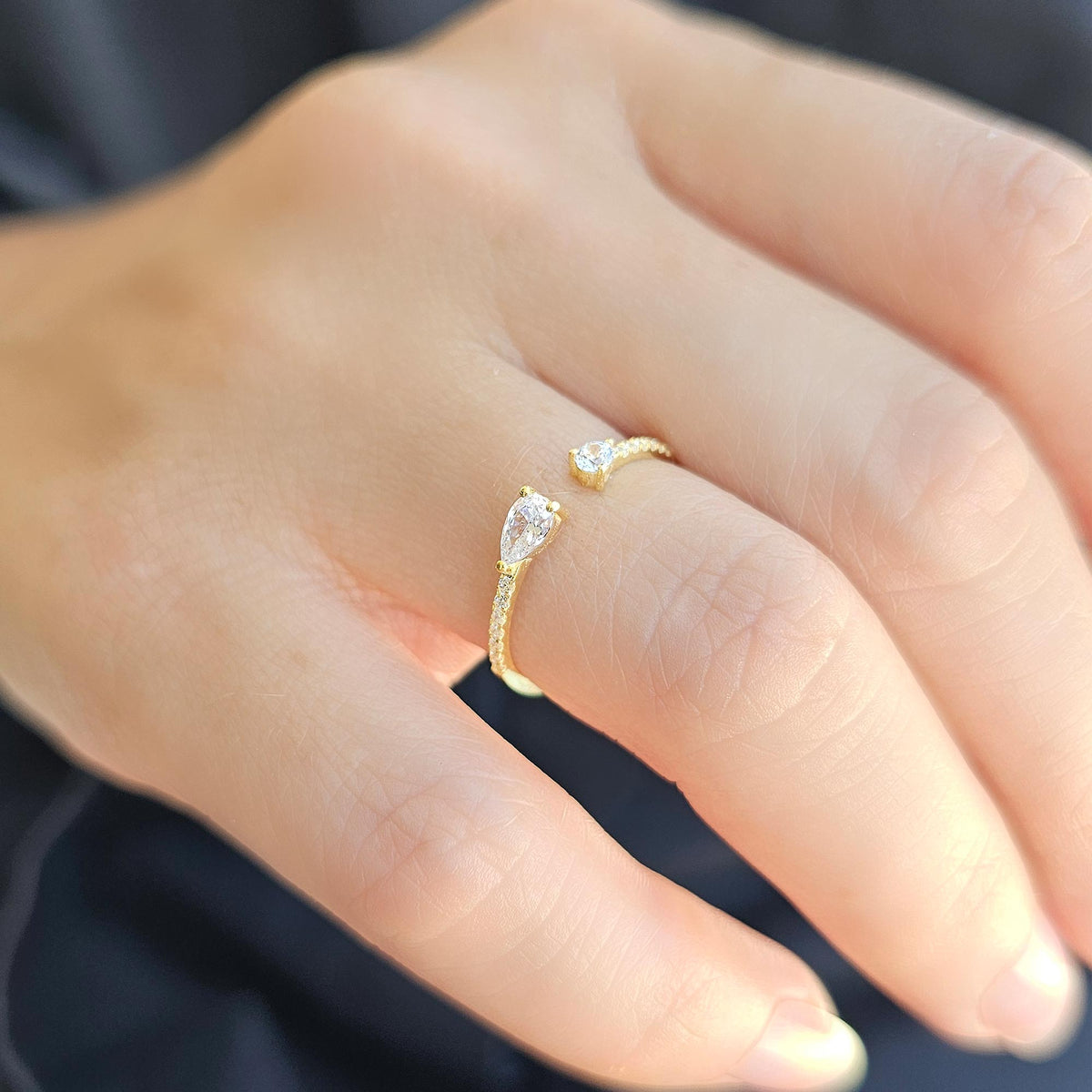 Gold pear open ring worn on hand, side view