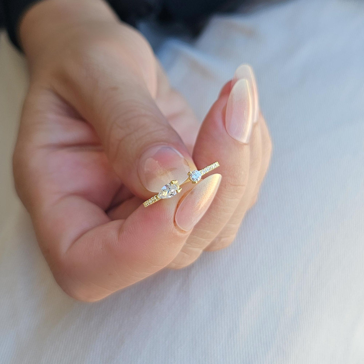 Gold pear open ring on raised hand