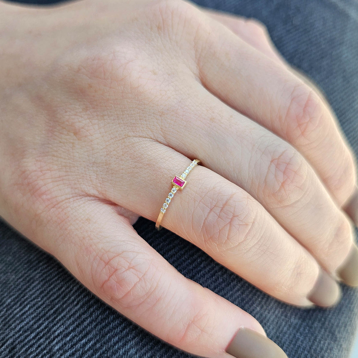Gold red-stone baguette ring worn on hand