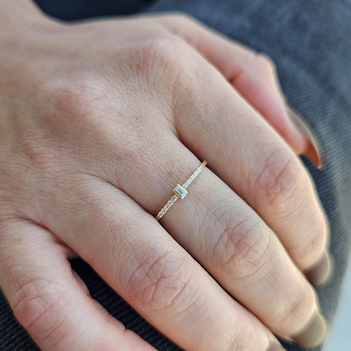Gold white-stone baguette ring worn on hand