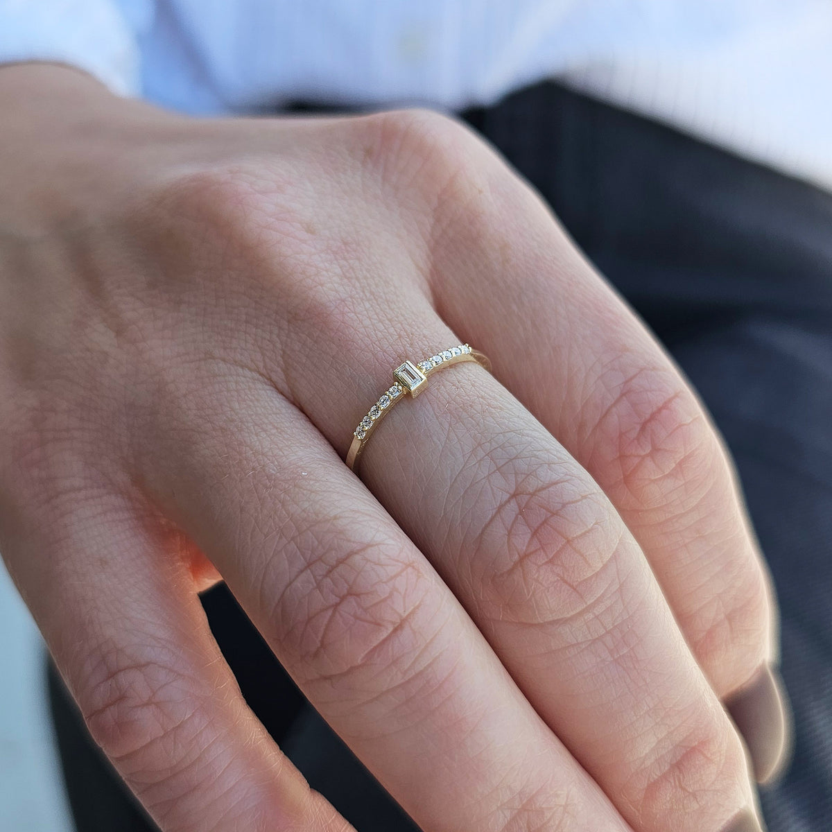 Gold white-stone baguette ring worn on hand, close-up