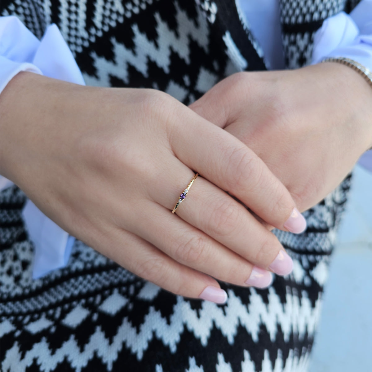 Gold purple-stone three-stone oval ring worn on hand