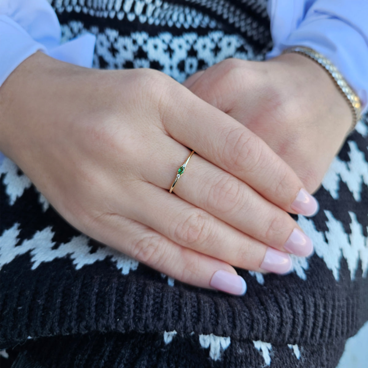 Gold green-stone three-stone oval ring worn on hand