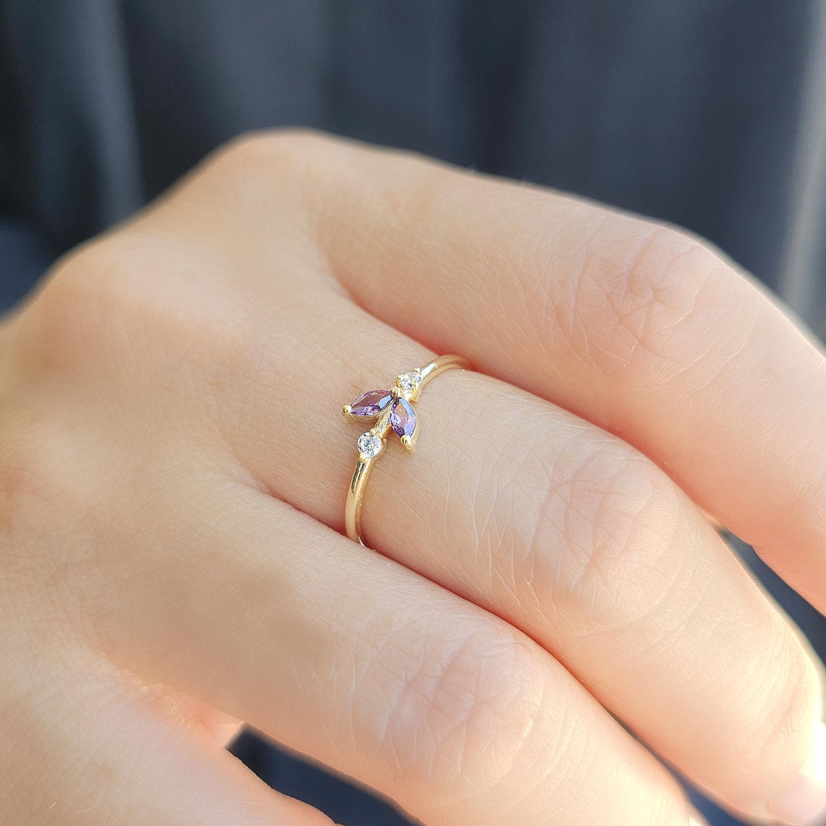 Gold purple-stone marquise leaf ring worn on hand, side view