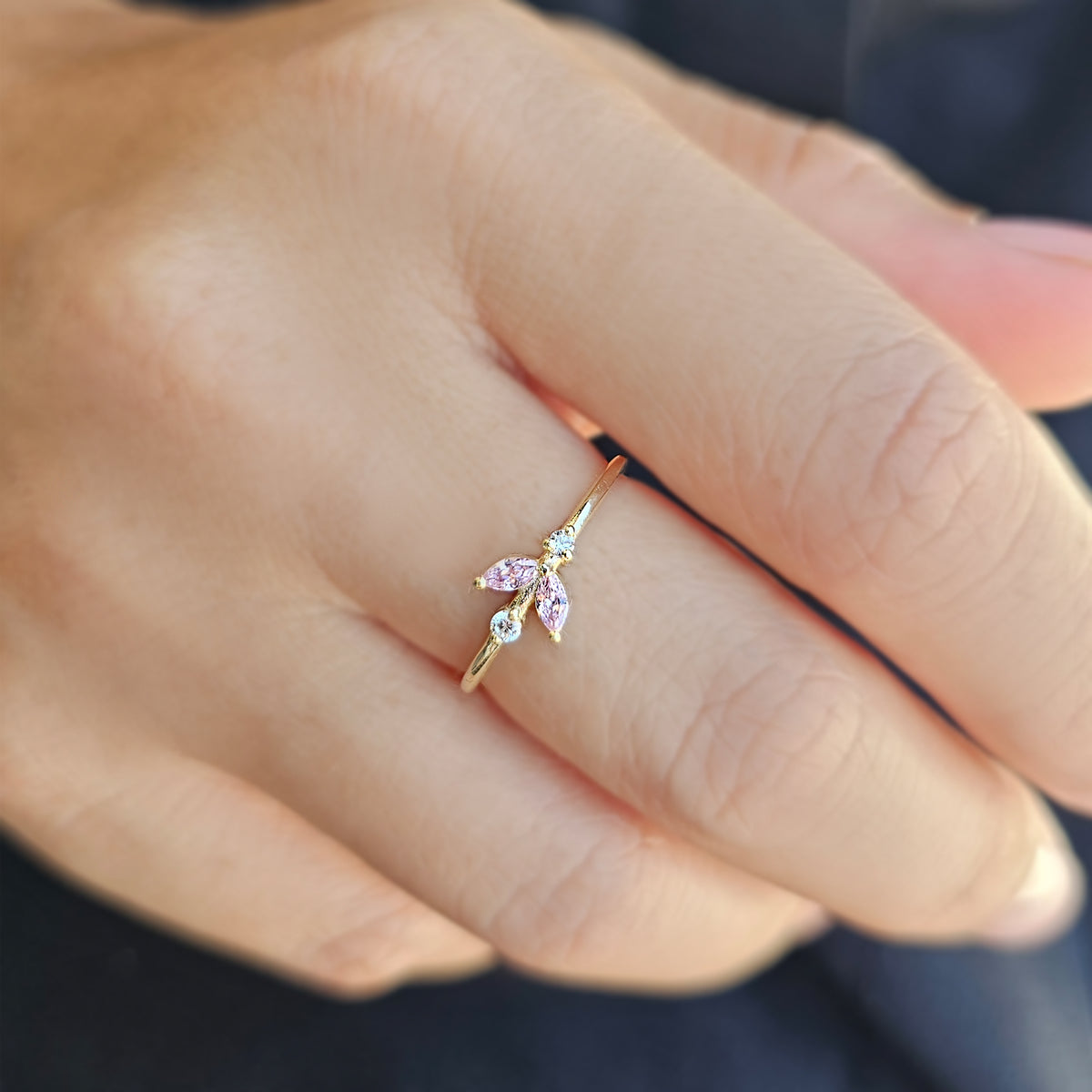 Gold pink-stone marquise leaf ring worn on hand, side view