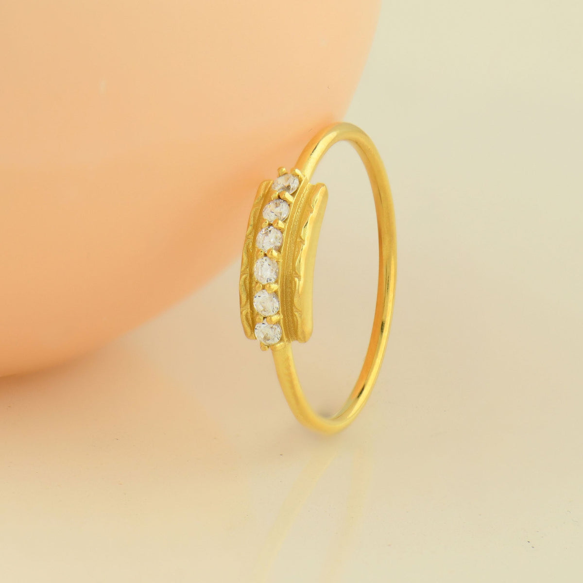18K gold modern six stone cubic zirconia ring on display