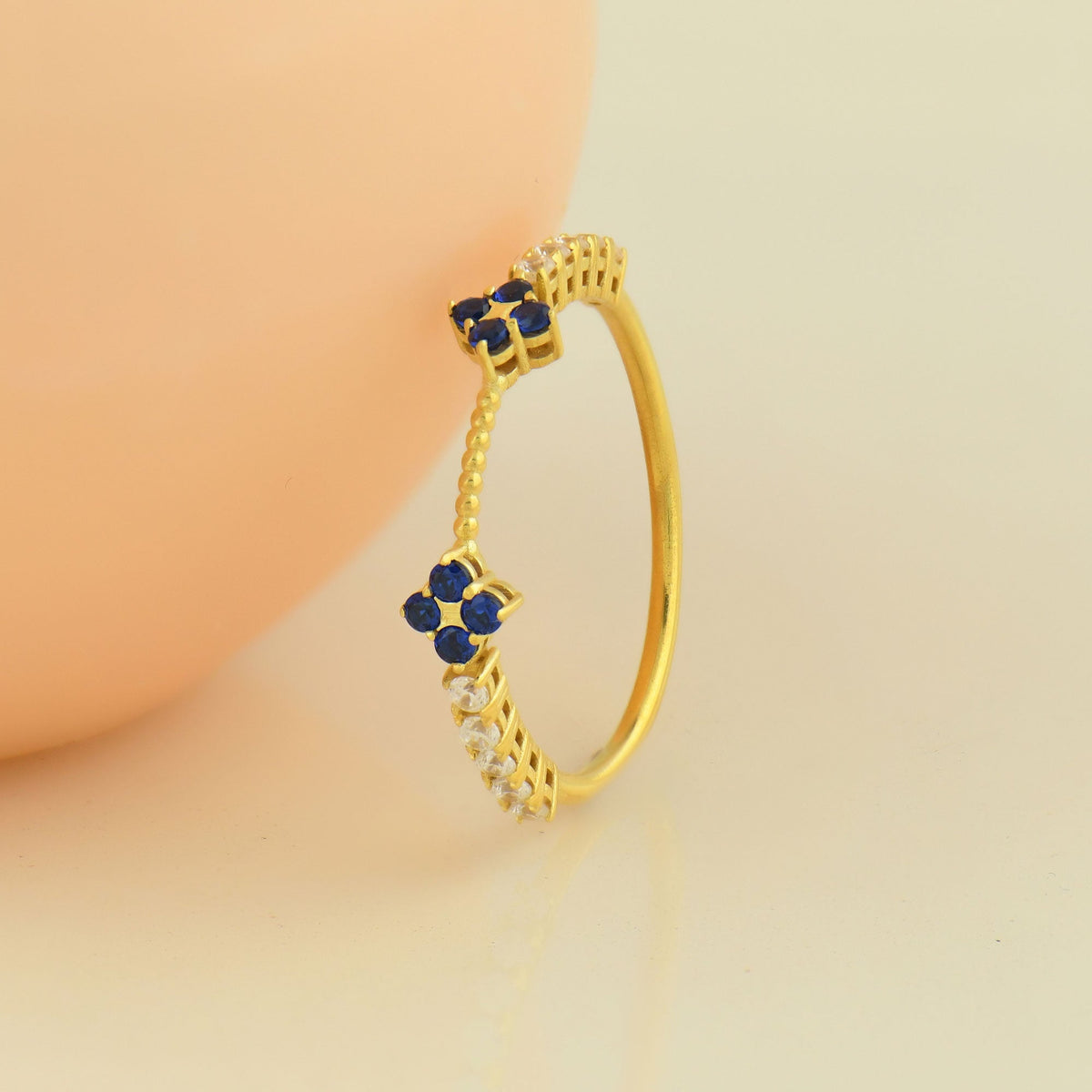 14K gold blue-stone double clover diamond ring on display