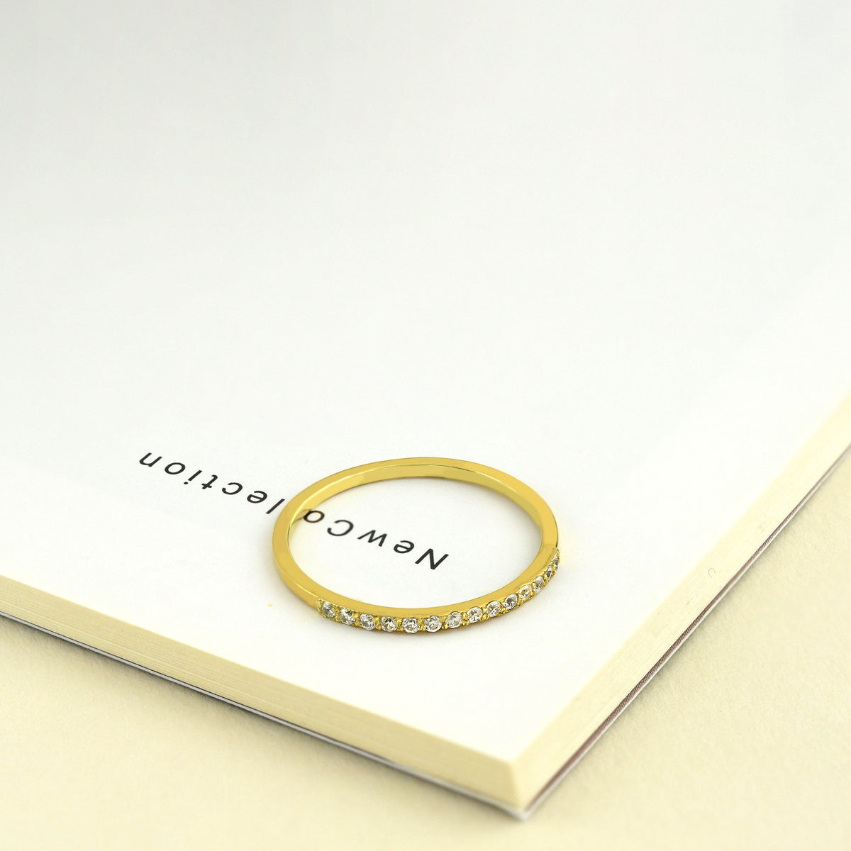 14K gold milgrain half eternity cubic zirconia ring on display