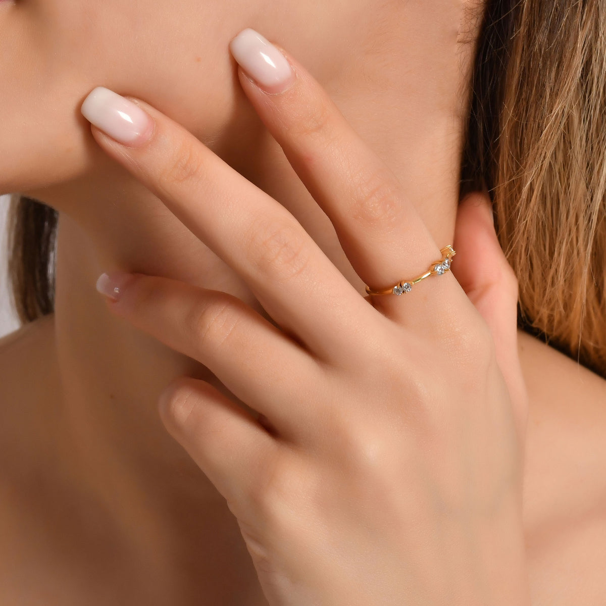 Gold six-stone stacking ring worn on hand