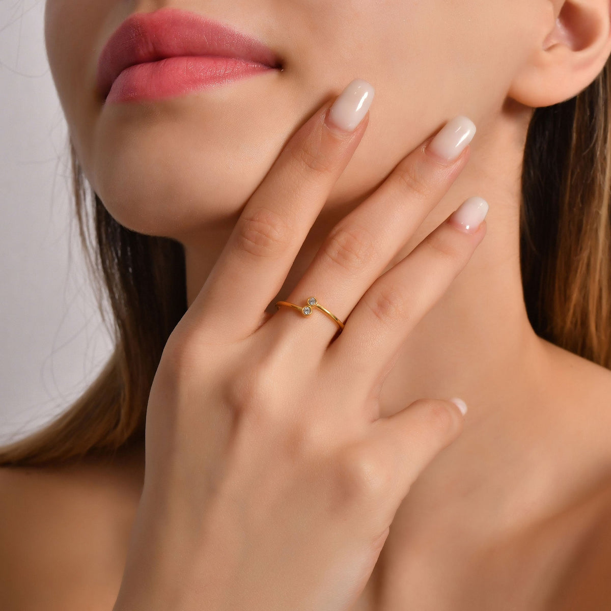 18K gold toi et moi bezel diamond ring on finger, close-up