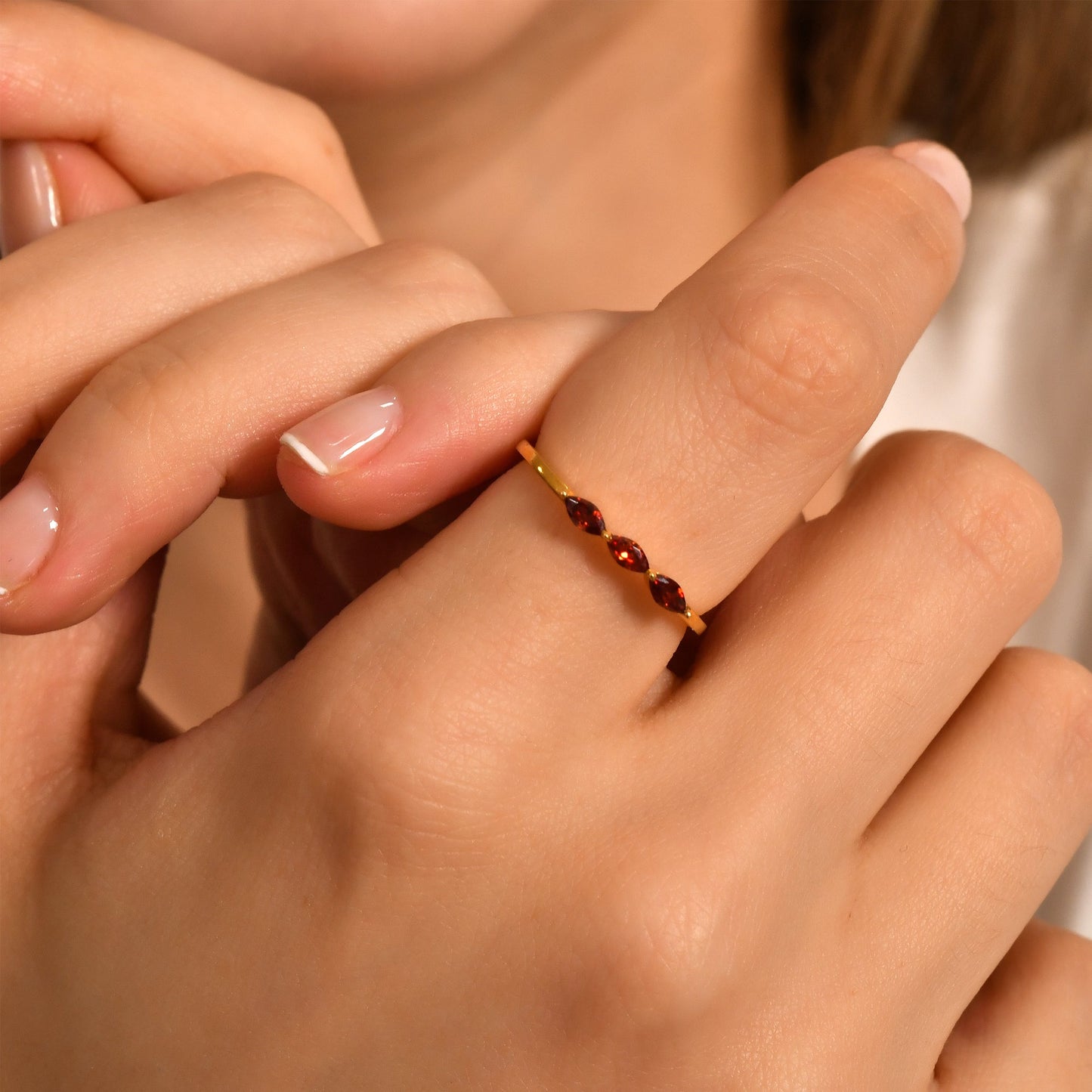 14K gold three stone marquise ring with orange-red marquise stones worn on hand