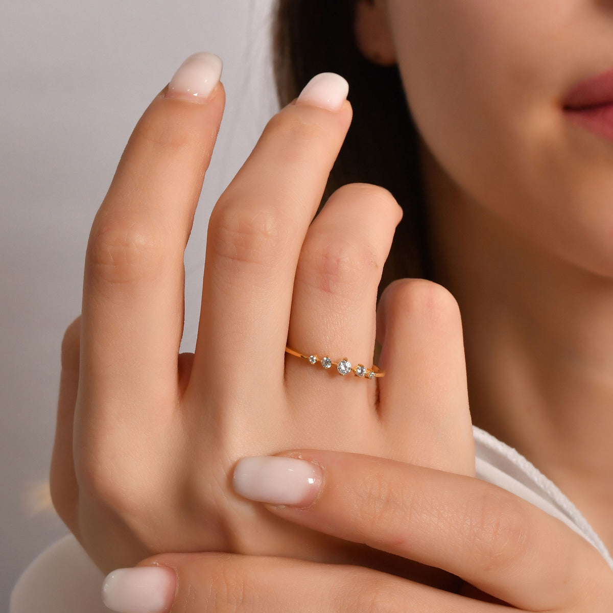 10K gold graduated five stone diamond ring on finger, close-up
