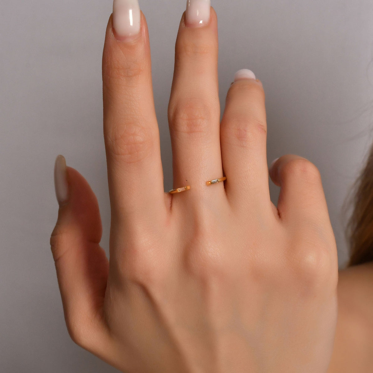 18K gold open baguette diamond ring on finger, close-up