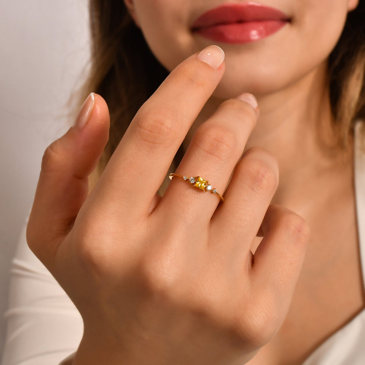 14K gold yellow-stone princess diamond ring on finger, close-up
