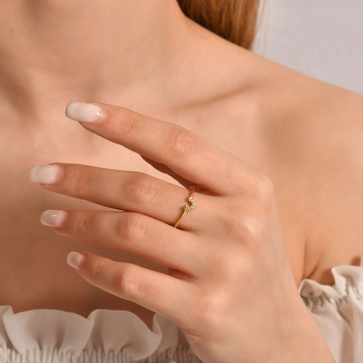 14K gold horseshoe cubic zirconia ring on raised hand