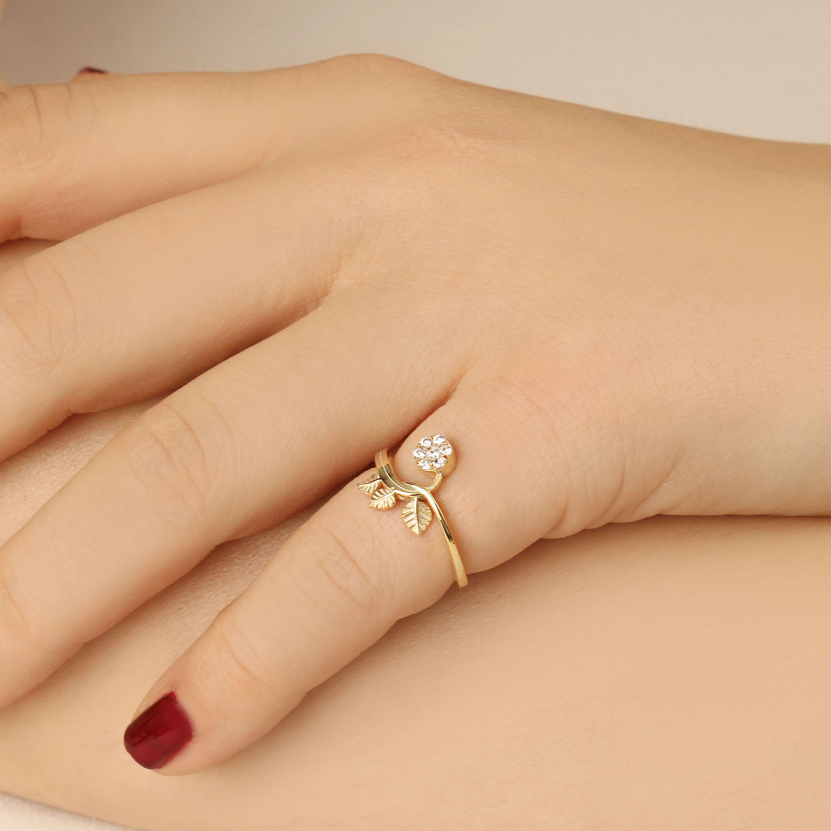 18K gold cluster leaf cubic zirconia ring on raised hand