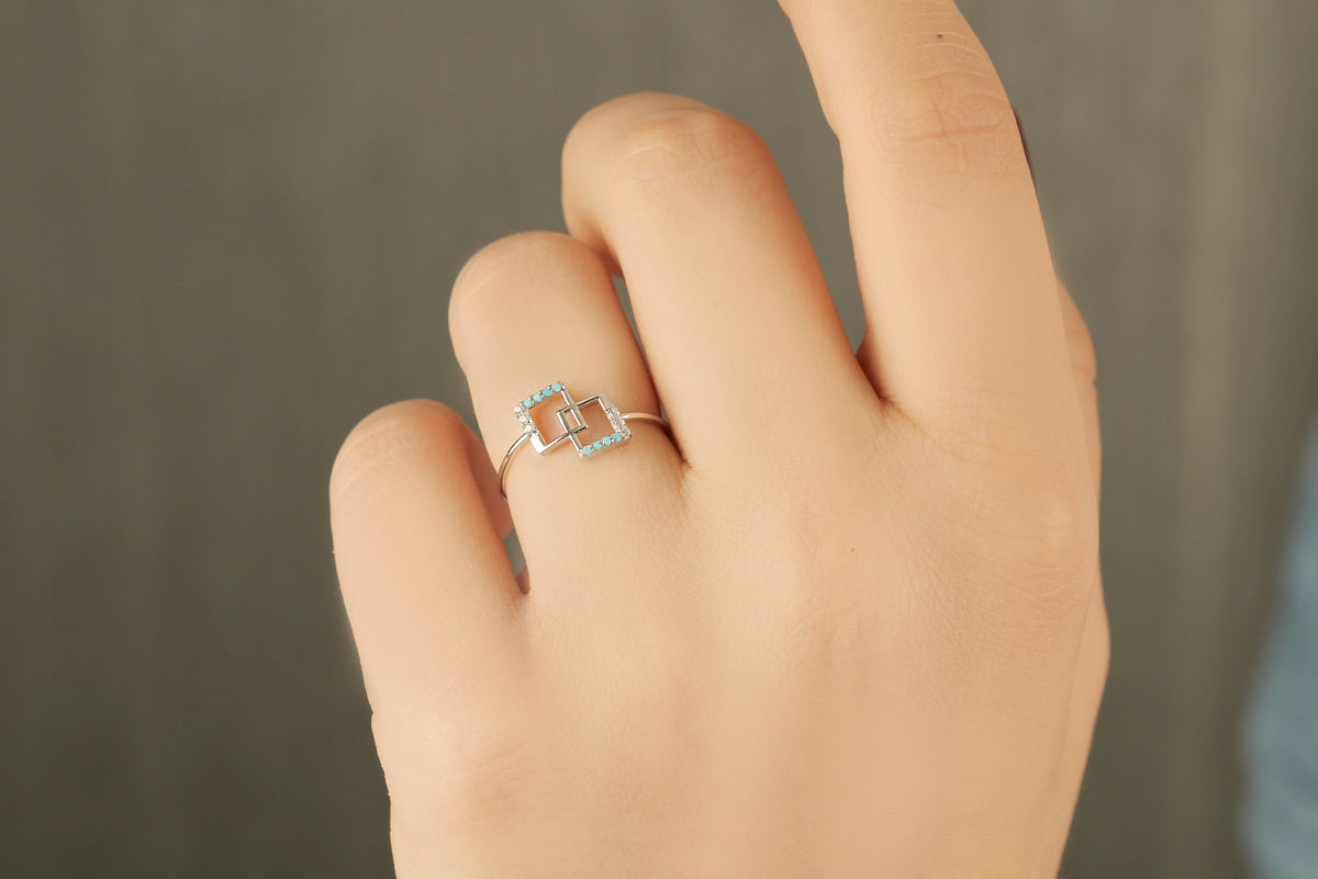 18K gold geometric square ring with turquoise stones and natural diamonds worn on hand, close-up