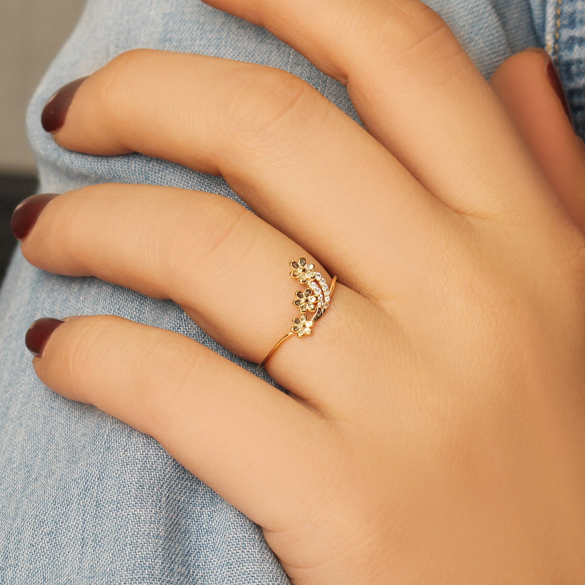 18K gold minimalist flower diamond ring worn on hand, side view