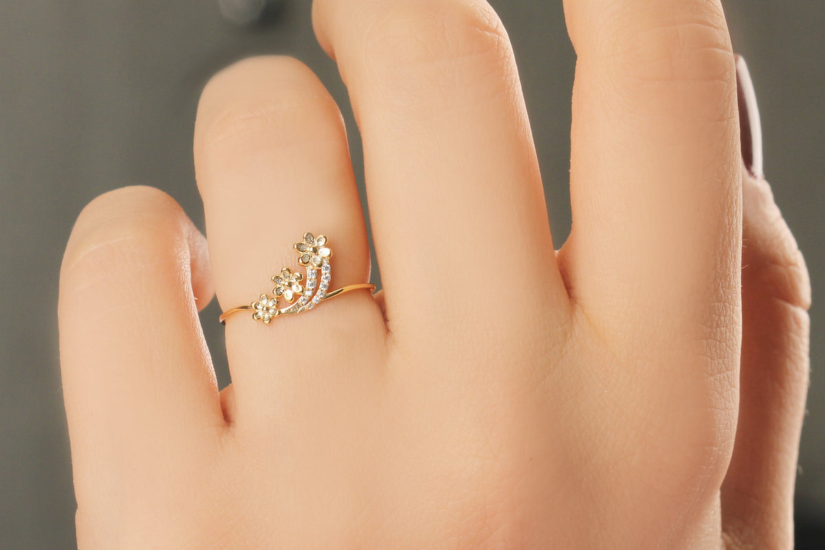 14K gold minimalist flower diamond ring on raised hand