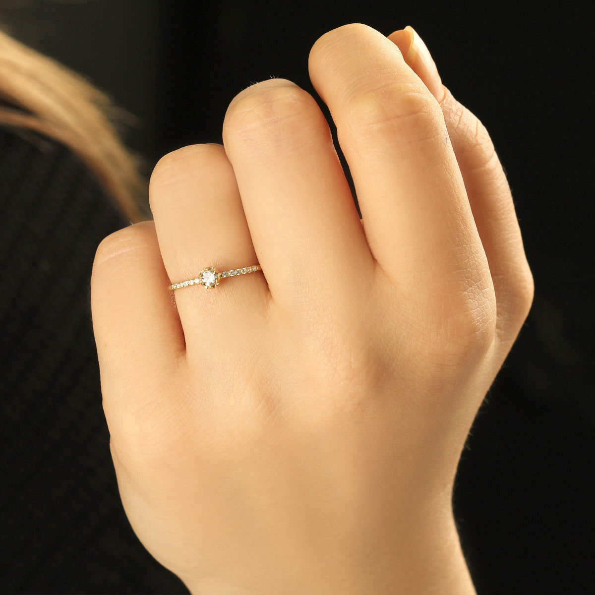 18K gold solitaire engagement cubic zirconia ring on finger, close-up