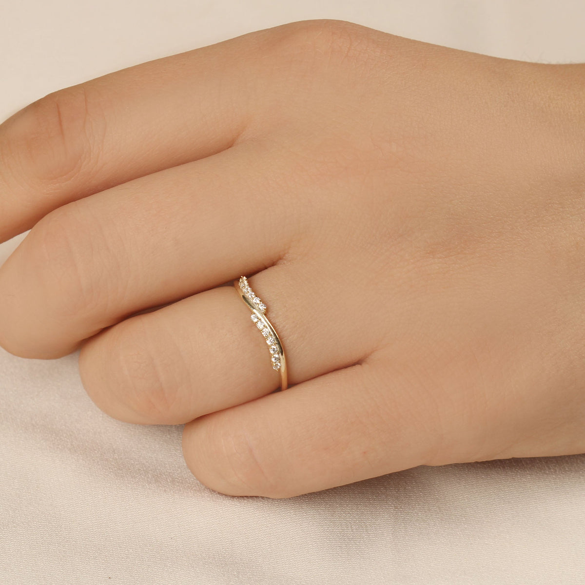 18K gold curved wave diamond ring on hand, natural light